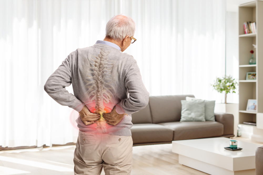 anciano con dolor sujetándose la parte baja de la espalda