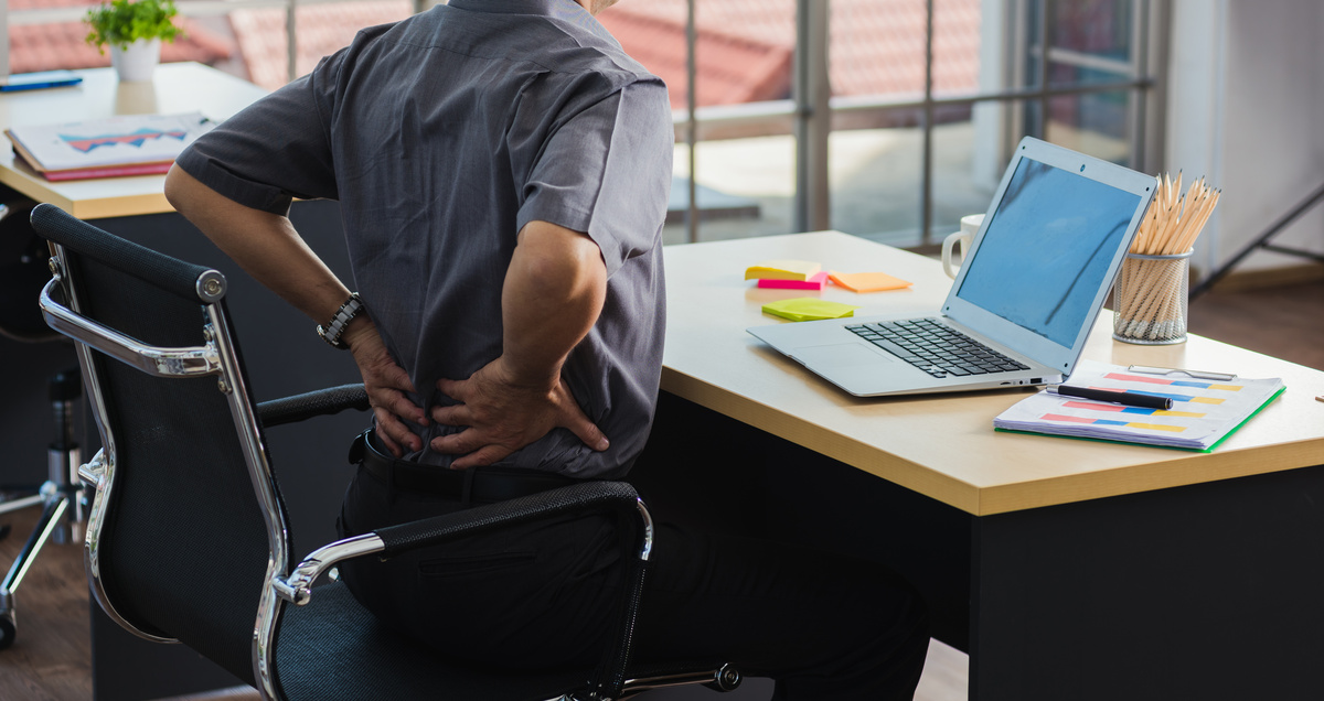 Asiático duro hombre de negocios de alto nivel que trabaja con el ordenador portátil tiene un problema con el dolor de espalda. Anciano sintiendo dolor después de estar sentado en el escritorio mucho tiempo, Concepto de síndrome de oficina de salud y medicina.